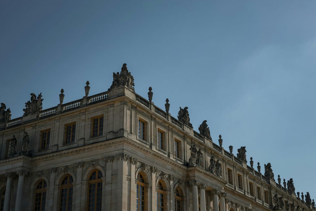 Stunning view of the Palace of Versailles' intricate architecture under a clear blue sky.